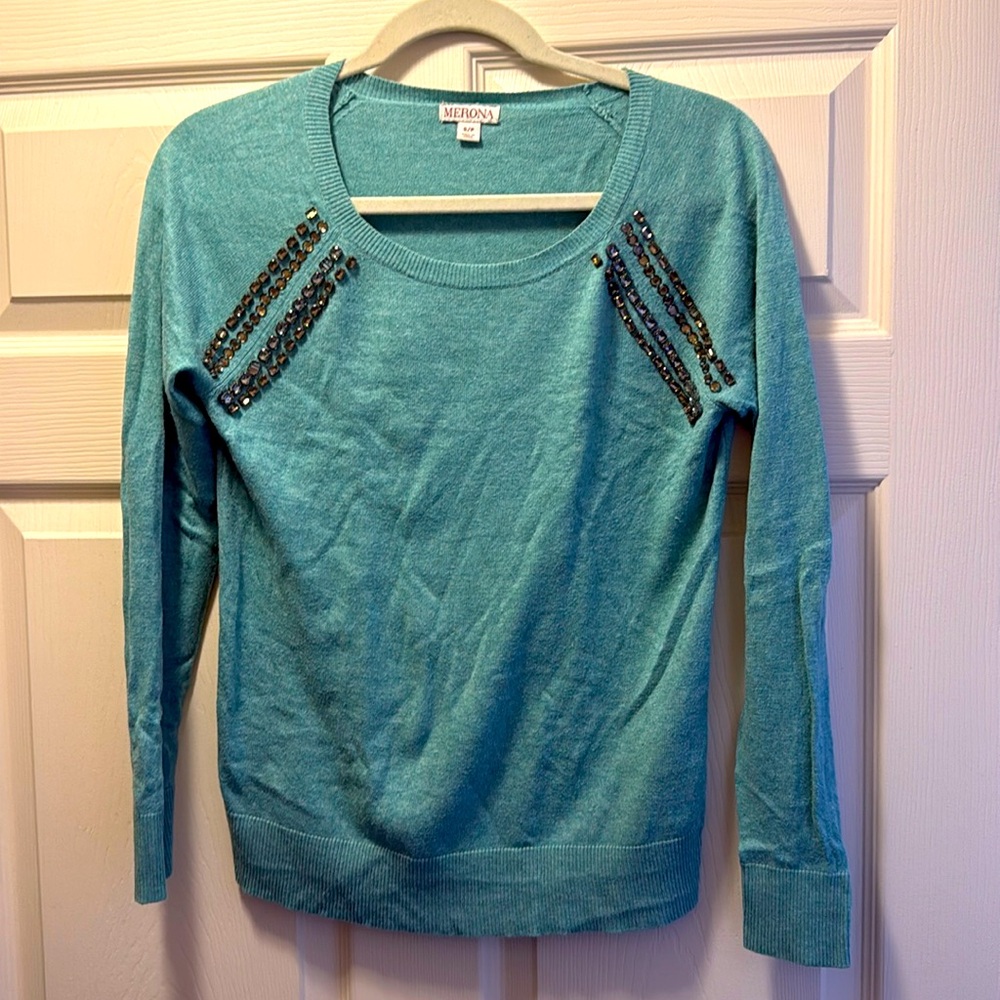 A Medona turquoise sweater with heels on the shoulders. Sizes small.